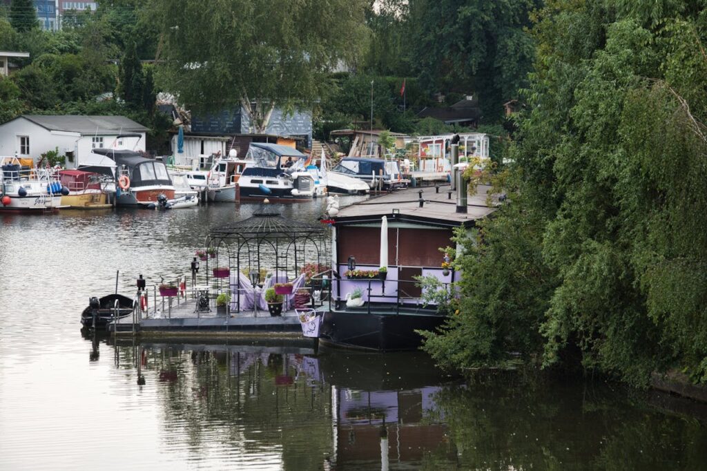 Picturesque scene of boats moored by a lush riverside, featuring a charming floating restaurant.
